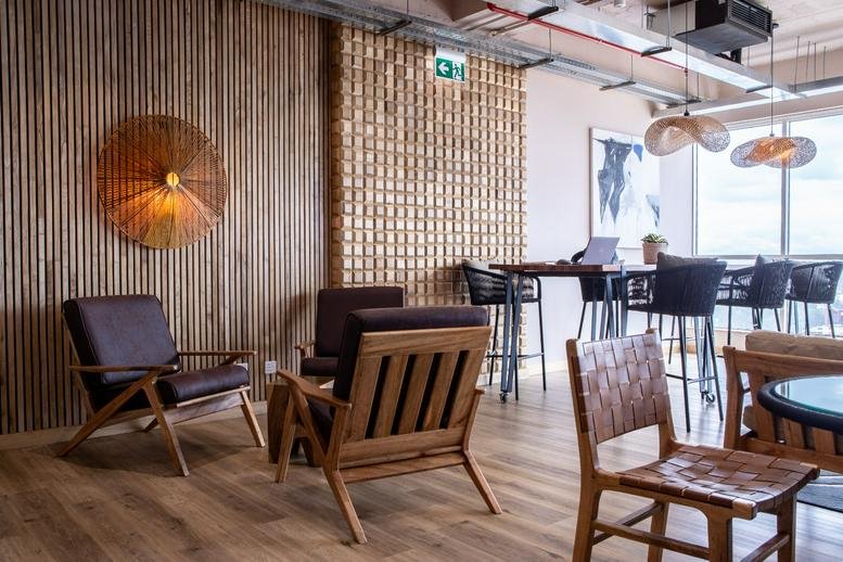 Spacious lounge at Mercure Nairobi Upper Hill with wood slat walls and mid-century modern armchairs.