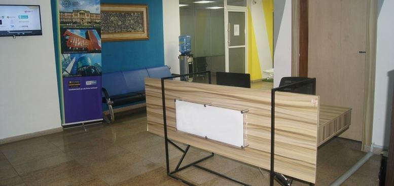 Bright reception area at 2nd floor, CMD 8 Jubilee Road, Lagos featuring a wooden desk and teal accent wall.