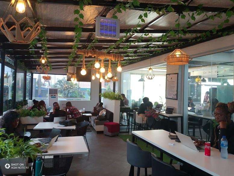 Spacious communal lounge at Obafemi Awolowo Way, Ikeja, Lagos, Nigeria with warm hanging lights and hanging vines.