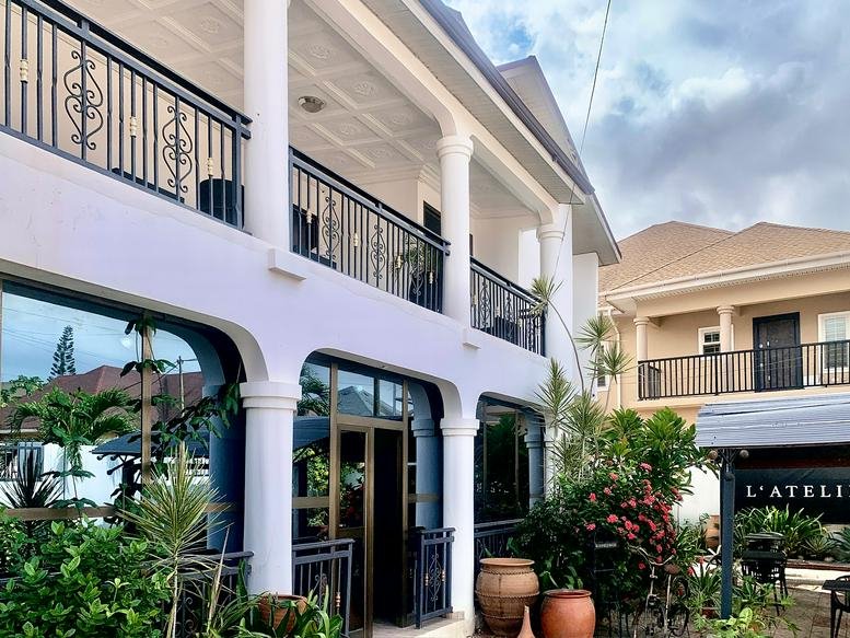 Exterior view of the white multi-story L'Atelier building with arched windows and balconies.