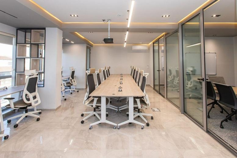 Spacious open-plan coworking area at Pixel Coworking featuring long wooden tables and ample natural light.