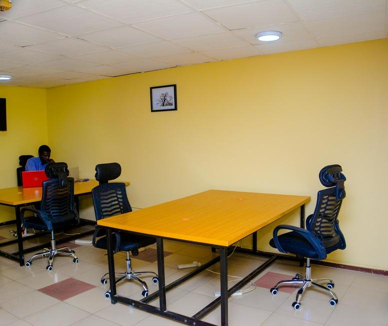Bright workspace at Cocoa House, 9th Floor, Dugbe, Ibadan, Nigeria with yellow walls and collaborative desks.