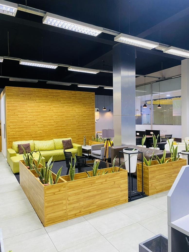 Large breakout lounge featuring a vibrant yellow wood-paneled wall and lime green sofa.