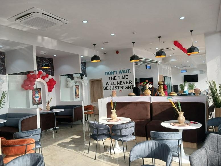 Modern lounge at Uptown Mall, Zaire Road, Barnawa, Kaduna, Nigeria with plush seating and decorative wall quotes.