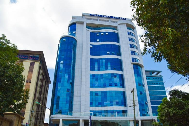Exterior view of the blue glass-facade Westpark Towers building against a bright sky.