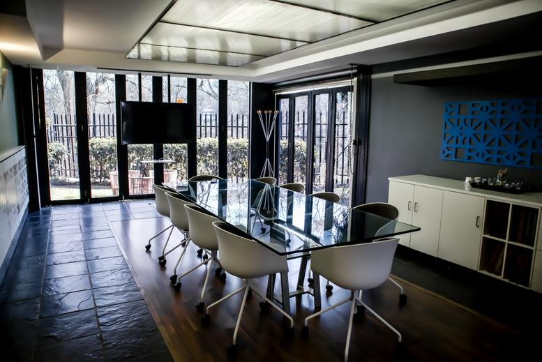 Elegant boardroom with a large glass table and floor-to-ceiling windows.