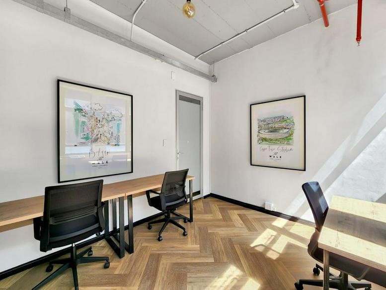 Private office suite with light wood floors and two modern workstations.