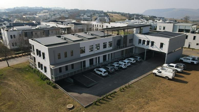 Exterior view of the multi-story Heron House building with solar panels and a paved parking lot.