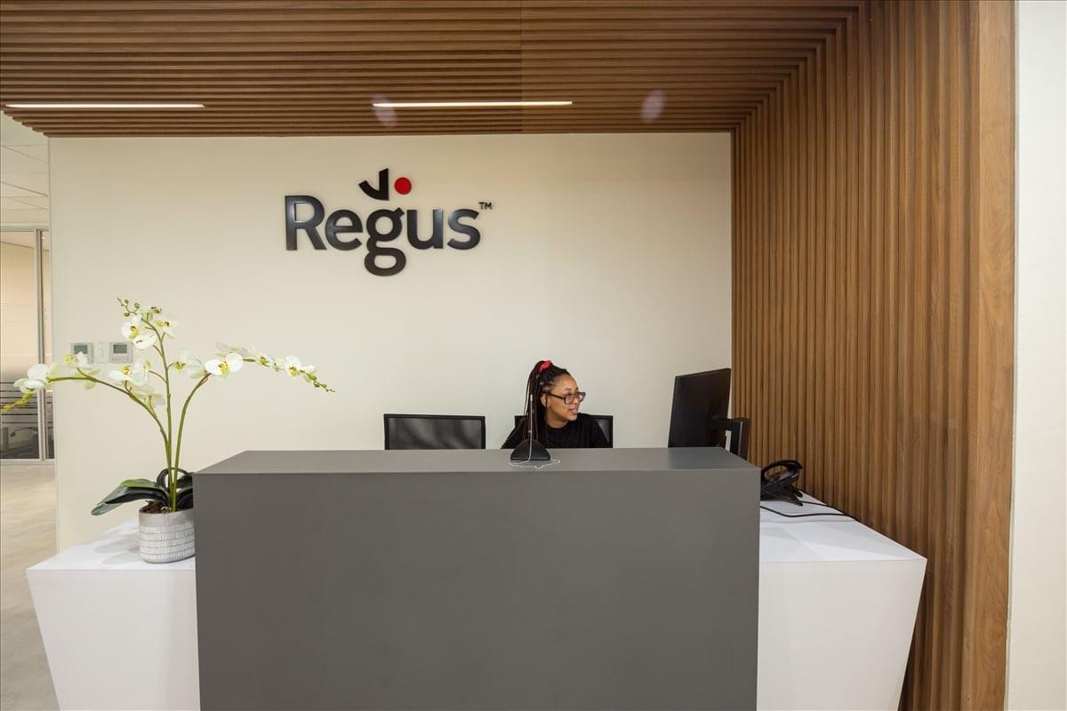Modern reception desk at Mac Building, Ground Floor, Magwa Crescent featuring wood-slat wall paneling.
