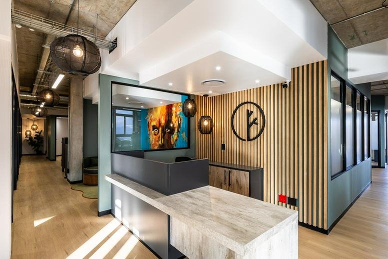 Reception area at Riverside Junction, 300 Bryanston Drive with a marble desk and wood-slat feature wall.