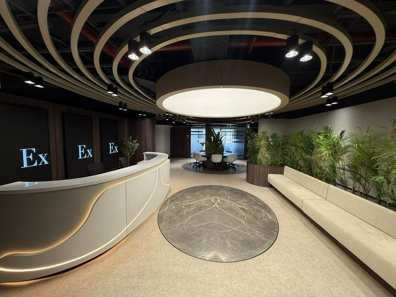 Modern lobby at road, New Cairo featuring a curved reception desk and designer ceiling lighting.
