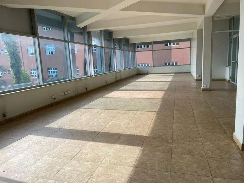 Spacious open-plan area with large windows and abundant natural light.
