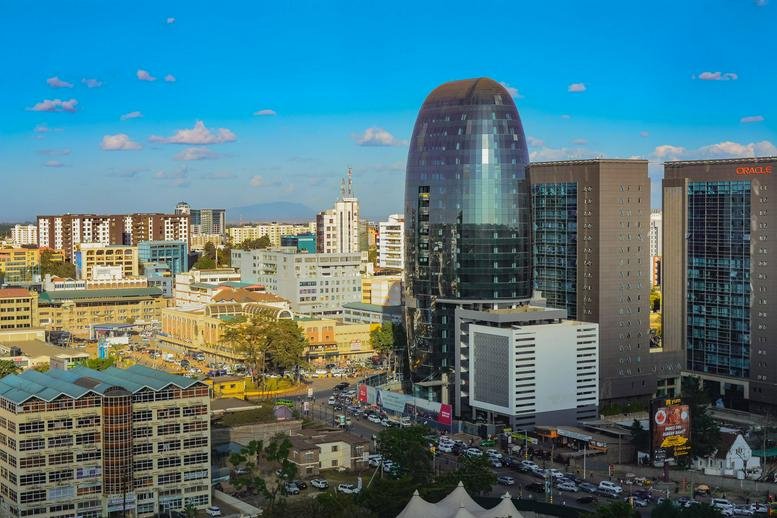Exterior view of the curved glass-facade One Africa Place skyscraper in the Nairobi skyline.