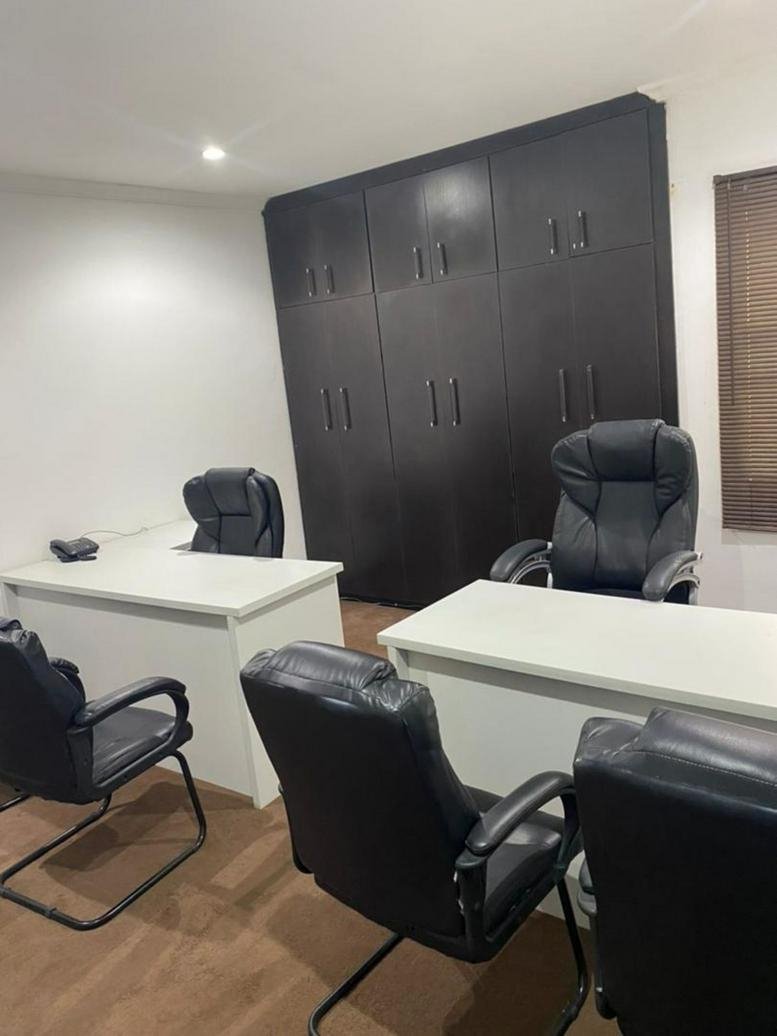 Four-person office suite at 19 Thaba Tseka Street, Wuse 2, Abuja, Nigeria featuring dark wood cabinetry.