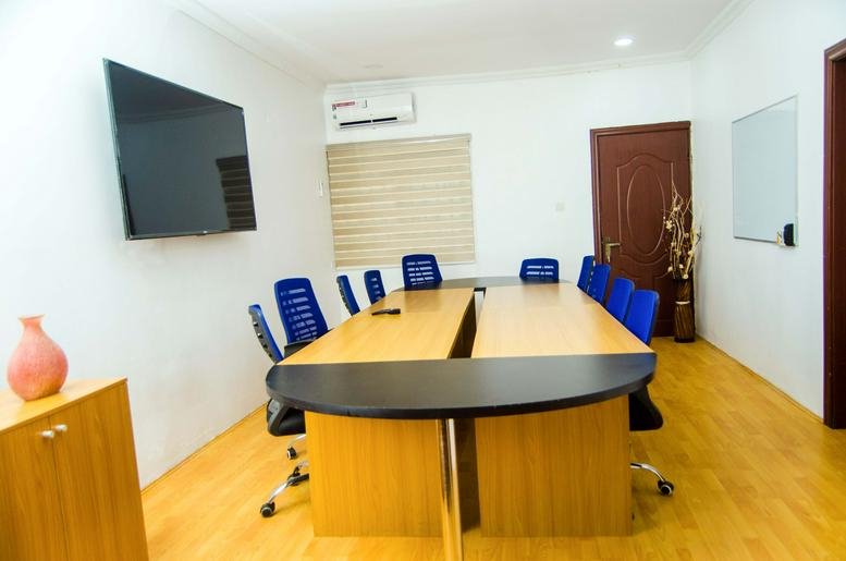 Meeting room with wooden floor and a large table with blue chairs