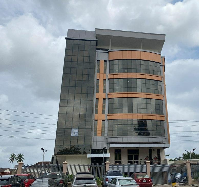 Exterior view of the modern glass and stone building at 2 Rev Ogunbiyi Street, Ikeja GRA.