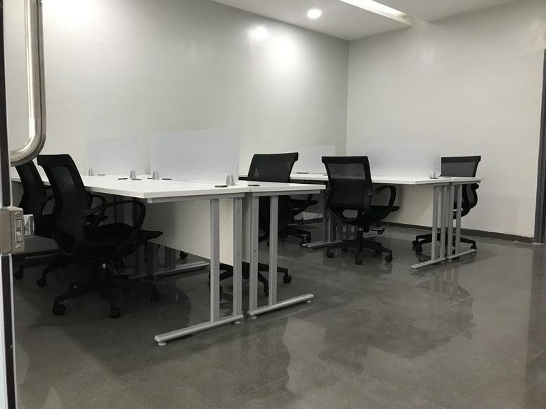 Private office space featuring white desks and grey floor-to-ceiling window blinds.