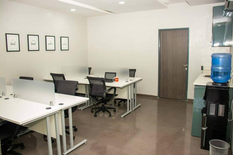 Shared office space at 21 Bekwere Wosu Street with multiple workstations and a water cooler.