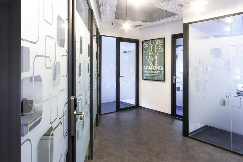 Bright hallway at 3 Al Massira Al Khadra Boulevard featuring glass office doors with geometric patterns.