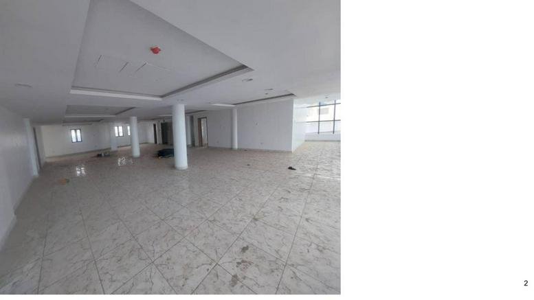 Spacious open-plan office floor with white walls and a tray ceiling.