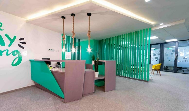 Reception area at 73 Boulevard d'Anfa, 7th Floor with a teal and grey desk and rope pendant lights.