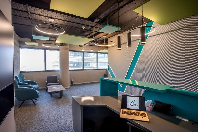 Spacious reception area with teal branding and lounge seating at Casa Business Tower.