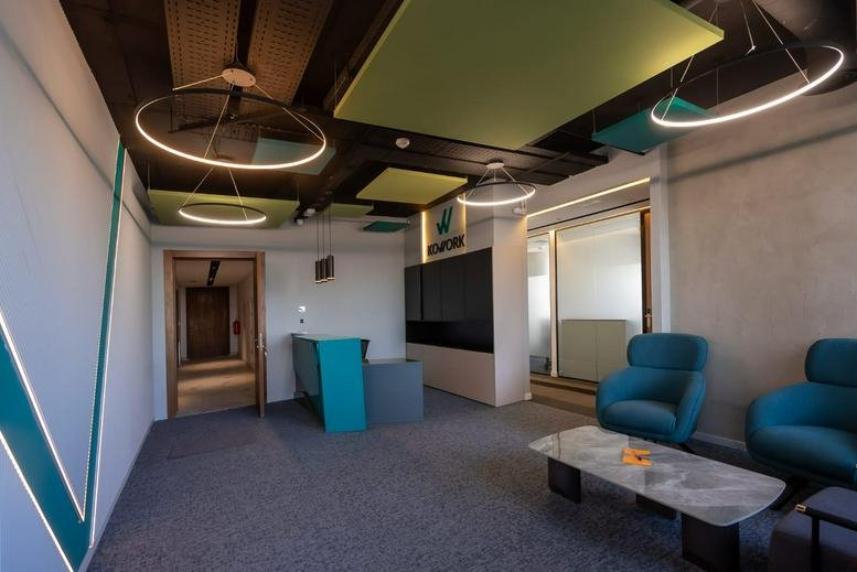 Spacious reception and lounge at Casa Business Towers with modern circular lighting and blue armchairs.