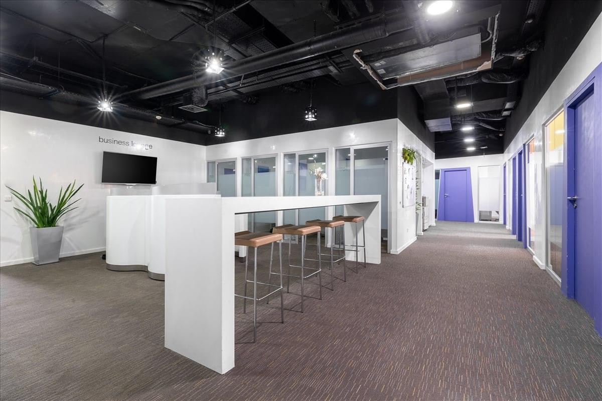 Spacious open-plan coworking area at Casa Shore 1 with a long white high-top table and bar stools.