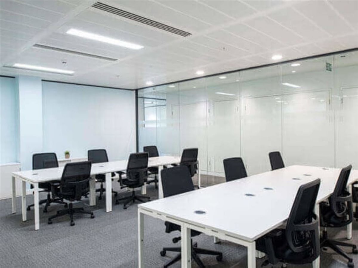 Spacious open-plan workspace at El Bunyan Boursas with multiple white desks and black ergonomic chairs.