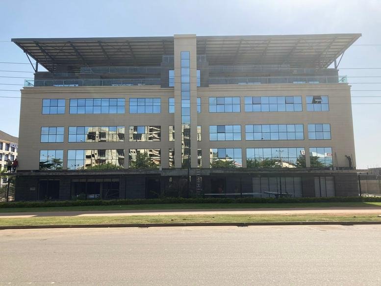 Exterior view of the modern Engicost building featuring a large overhanging roof and glass facade.