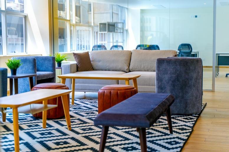 Bright breakout lounge at Twentieth Century Plaza with colorful ottomans and natural light.
