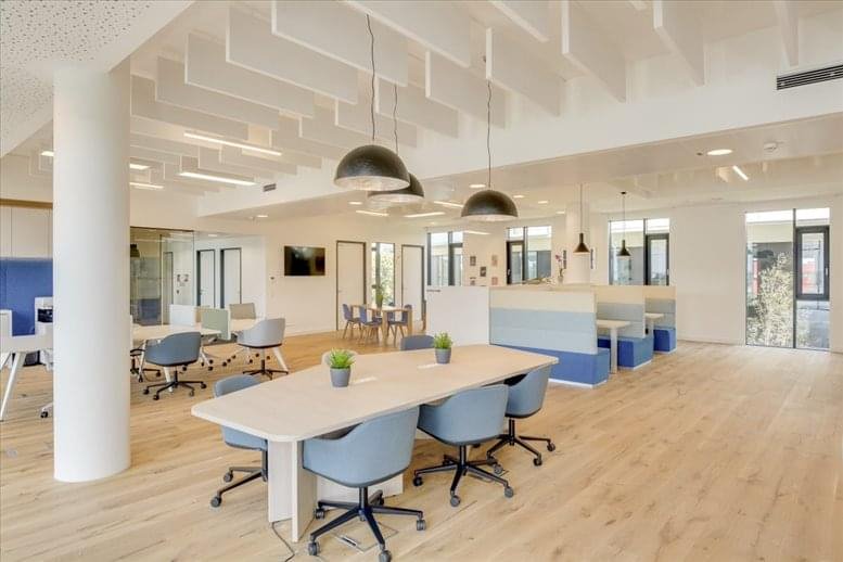 Spacious communal coworking area at Nairobi Business Park with modern lighting and blue seating booths.