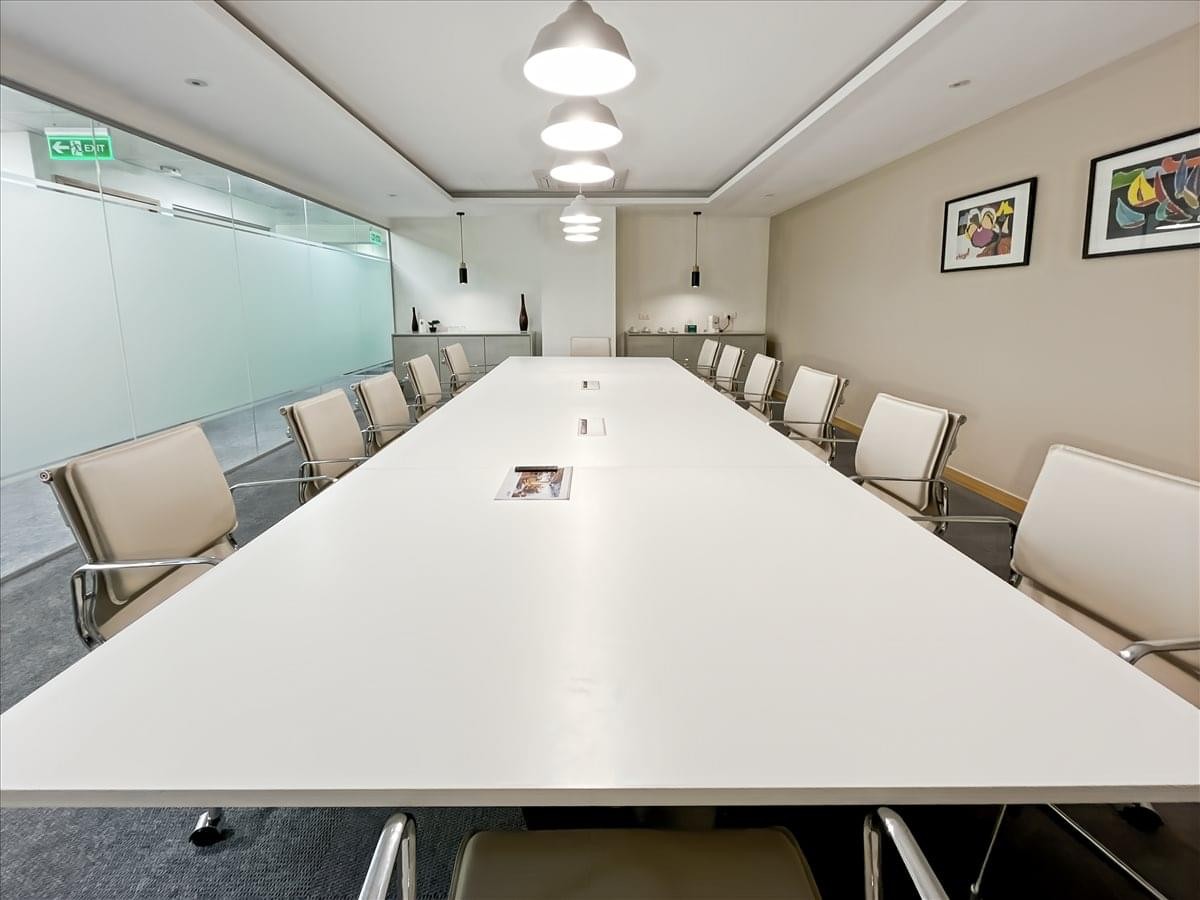 Formal boardroom in the Nexsky Building with a long white table, white leather chairs, and modern lighting.