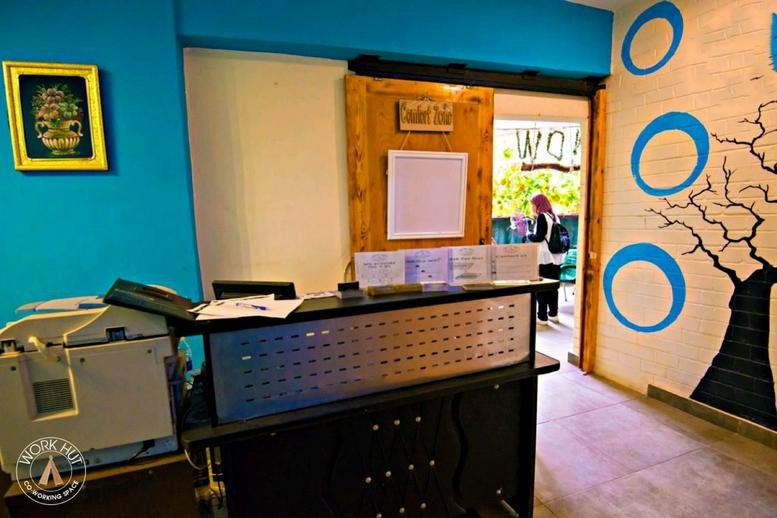 Reception area at El-Teraa El-Mardoma Street, Nour El-Islam featuring a blue feature wall and wooden front desk.