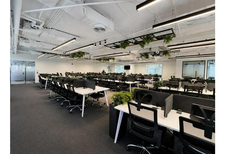 Spacious open-plan office at Regent's Park, South 90th, New Cairo with modern workstations and hanging greenery.