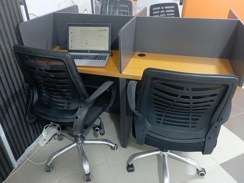 Twin workstations with privacy dividers and ergonomic chairs at Peaceful Tech Hub, 146 Church Street, Arepo, Nigeria.