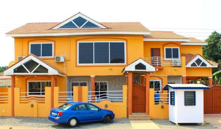 Exterior view of the orange and cream building at 22 Bissau Avenue, East Legon, Accra.