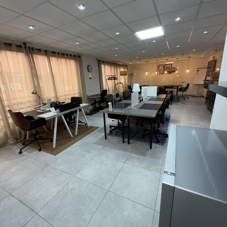 Wide view of Cowork'skech Centre d'Affaires Eden Park featuring multiple workstations and warm pendant lighting.