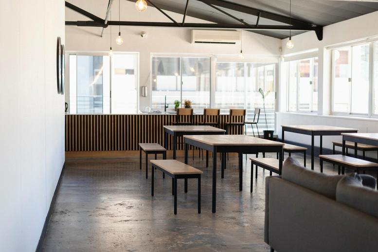 Spacious communal dining area with wooden tables and benches at 79 Loop Street, 9th Floor.
