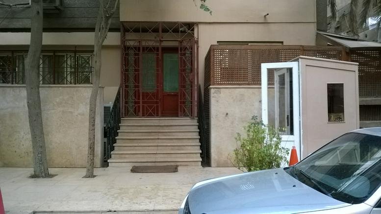 Exterior entrance of the 9 Tunis Street building featuring a staircase and security booth.