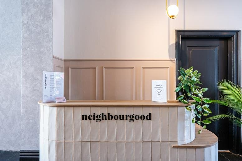 Modern reception desk with wooden paneling and building branding at 93 Bree Street.