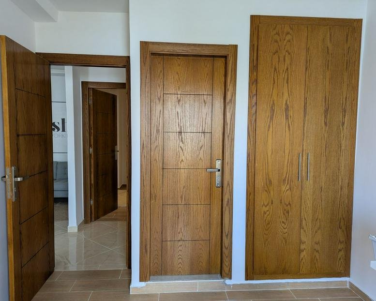 Hallway featuring matching light wood doors and a built-in wardrobe.