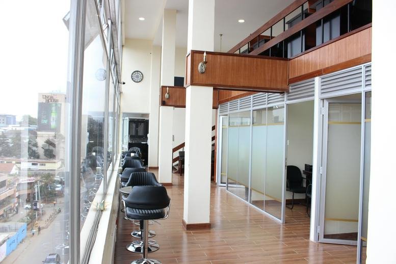 Bright hallway workspace at Aly’s Center with glass partitions and floor-to-ceiling windows.