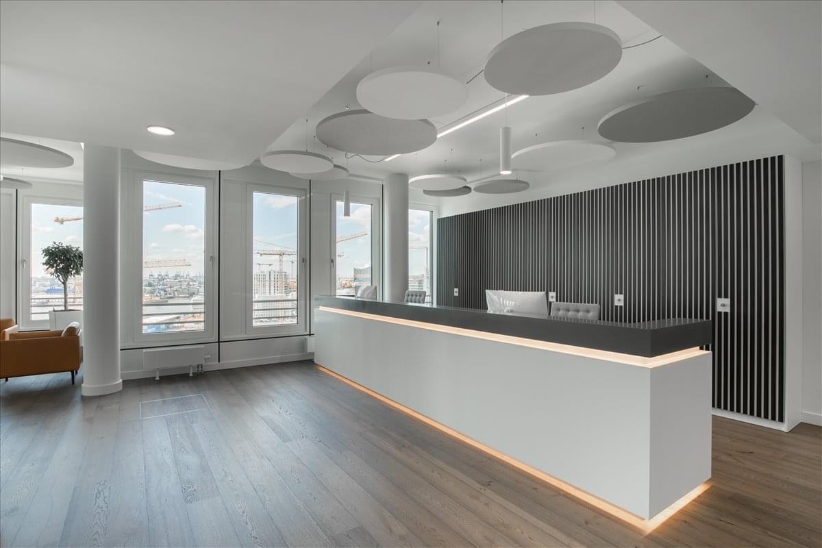 Spacious reception area of Arabella Country Club, Arabella Compound featuring a sleek white desk and acoustic ceiling discs.