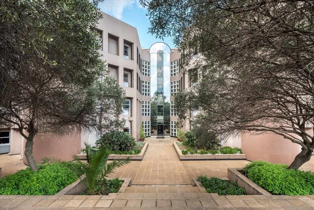 Exterior courtyard view of the modern Metropolitan Park office building with paved walkways and trees.