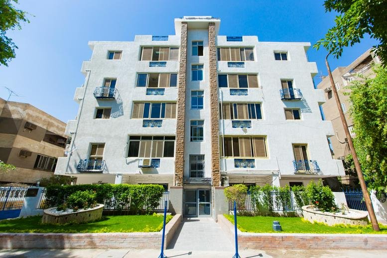 Exterior view of the white facade and garden at Building 17, Street 210, Victoria Square.