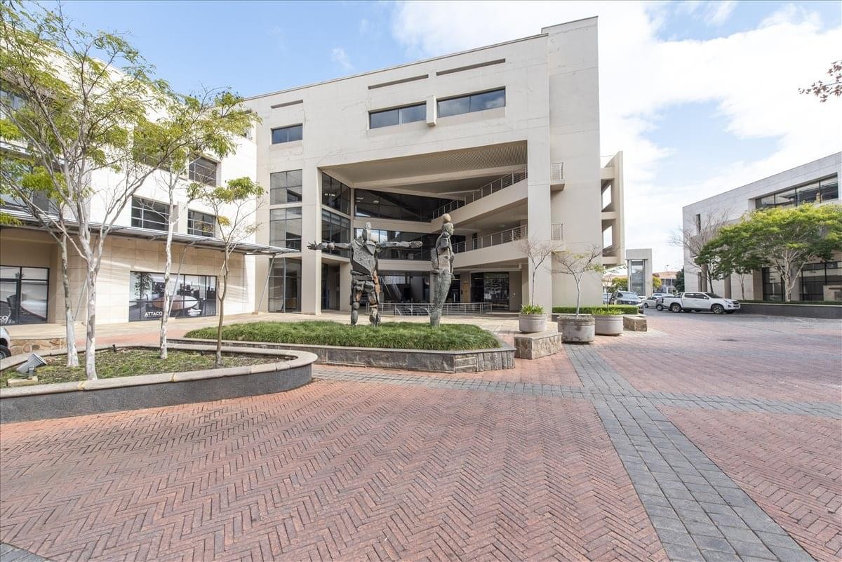 Exterior view of Building 2 at Brooklyn Bridge Office Park featuring modern architecture and a paved plaza.