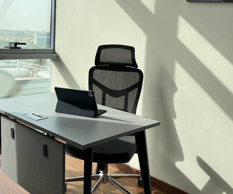 Single workstation with a tablet and ergonomic chair in a sunlit corner.