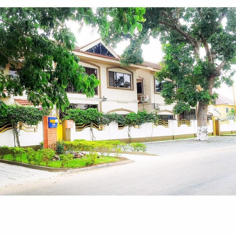 Exterior view of the Business Centre, C470/26 Abotsi Street, East Legon surrounded by lush trees and greenery.