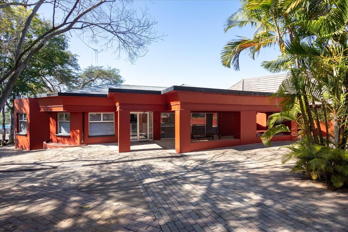 Exterior view of the red-walled office building at Corner of Ferreira Street & Van Der Merwe Street.